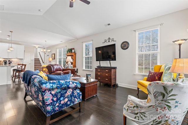 living room featuring ceiling fan with notable chandelier, dark hardwood / wood-style flooring, and vaulted ceiling