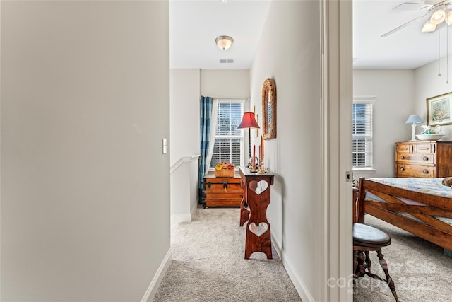 corridor featuring light colored carpet