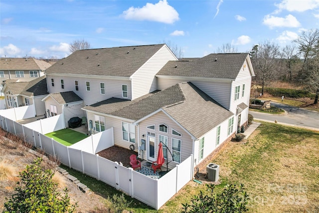 rear view of property with a yard and central AC unit