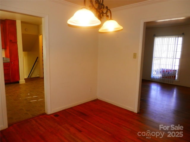 unfurnished room featuring baseboards, ornamental molding, and dark wood-type flooring