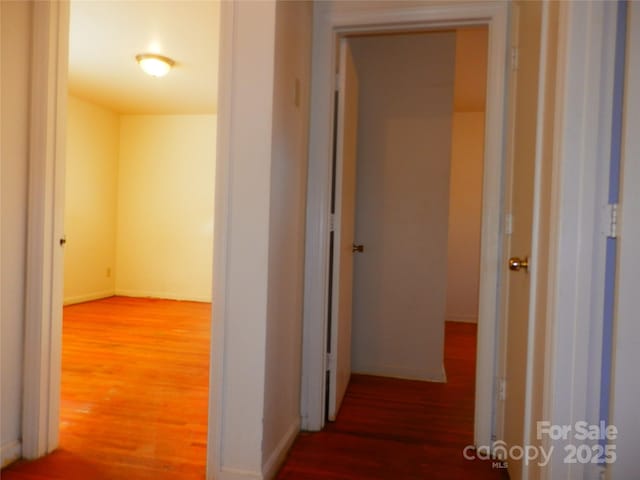 corridor with wood finished floors and baseboards