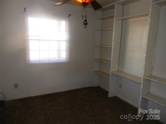 interior space with dark carpet and baseboards