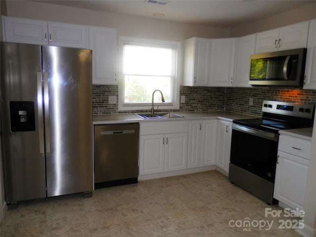101 Colony Acres Dr, Charlotte, NC 28217 - kitchen featuring stainless steel appliances, a sink, tasteful backsplash, and white cabinetry
