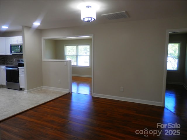 101 Colony Acres Dr, Charlotte, NC 28217 - kitchen featuring stainless steel appliances, wood finished floors, white cabinets, backsplash, and light countertops