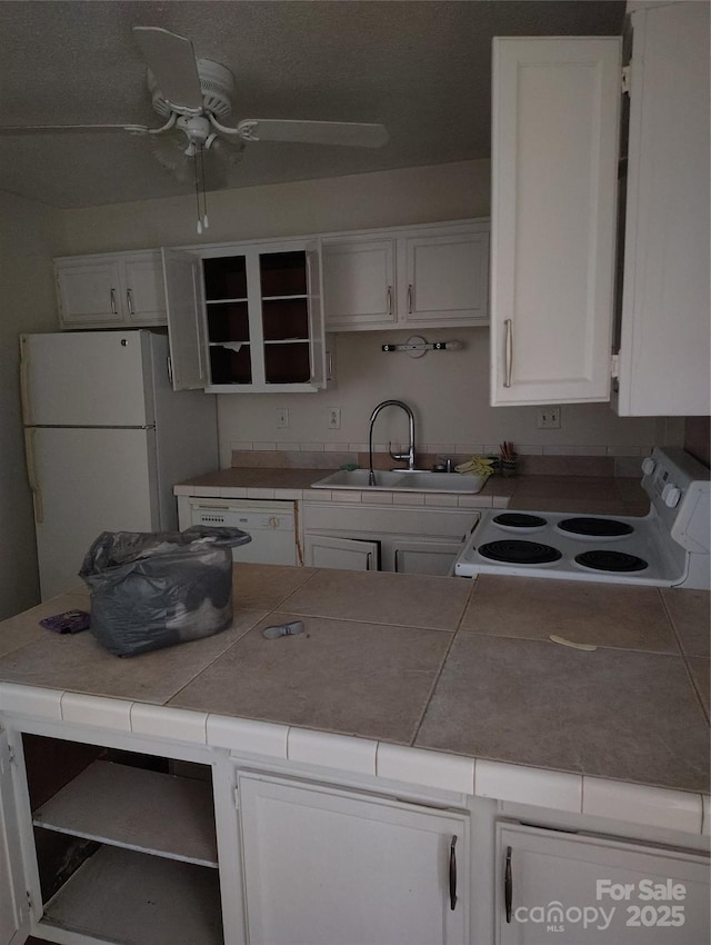 kitchen featuring white cabinetry, sink, tile counters, and white appliances