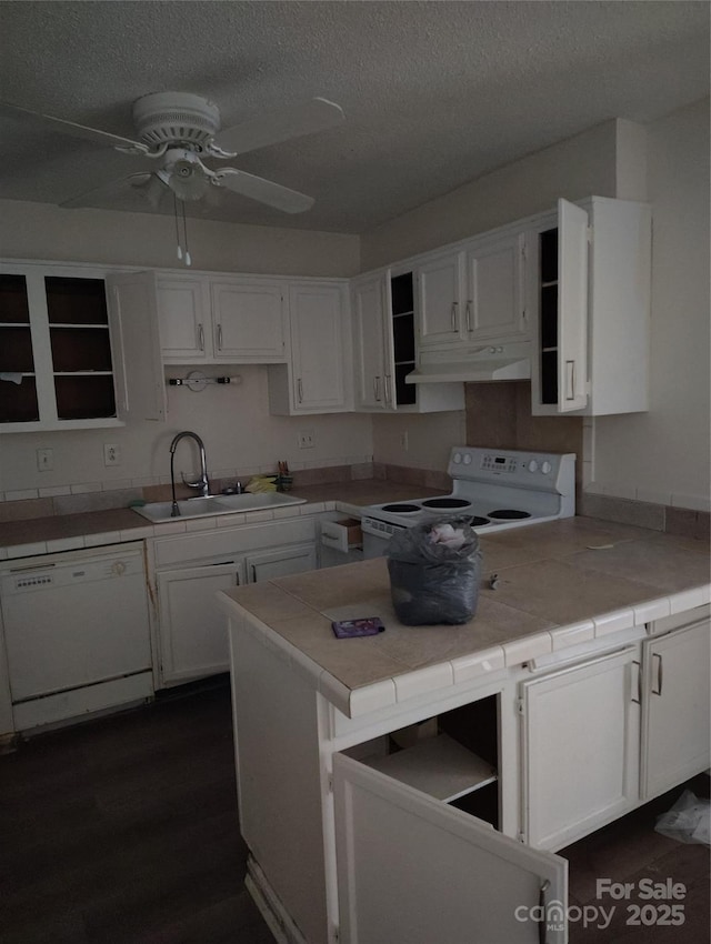 kitchen with white appliances, tile counters, sink, and white cabinets