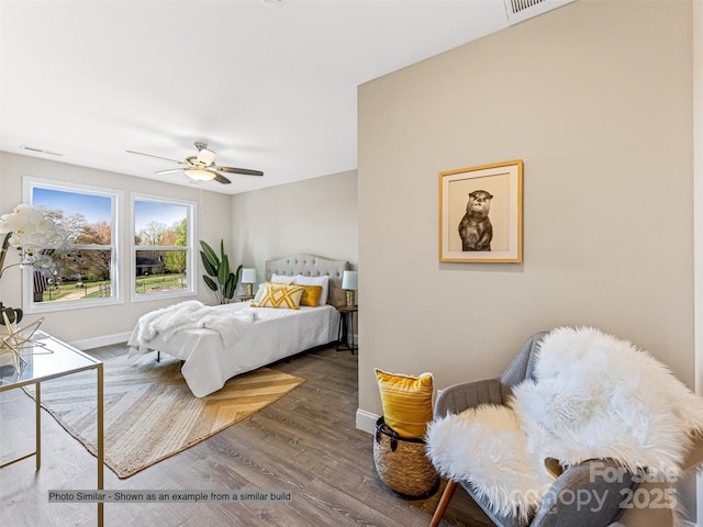 bedroom featuring a ceiling fan, wood finished floors, visible vents, and baseboards