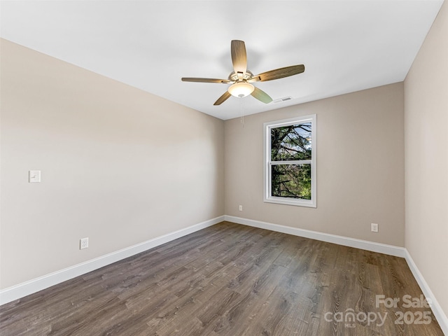 unfurnished room with visible vents, a ceiling fan, baseboards, and dark wood-style flooring