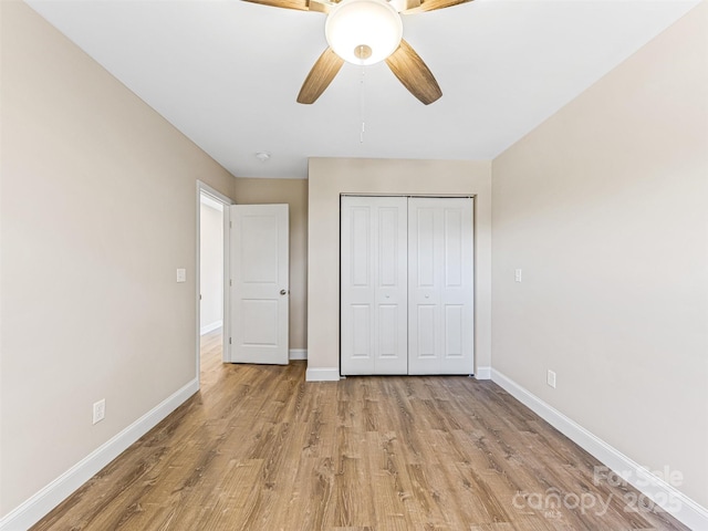 unfurnished bedroom featuring a ceiling fan, light wood-style floors, baseboards, and a closet