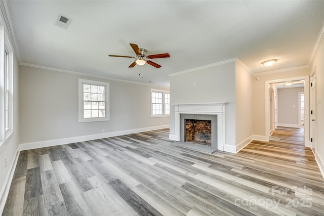 unfurnished living room with ornamental molding, a fireplace, light hardwood / wood-style floors, and ceiling fan