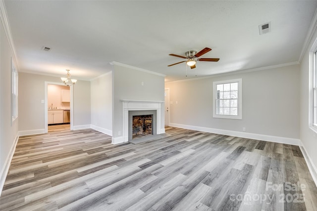 unfurnished living room with ornamental molding, sink, ceiling fan with notable chandelier, and light wood-type flooring