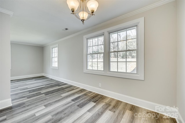 empty room featuring a notable chandelier, crown molding, and wood-type flooring