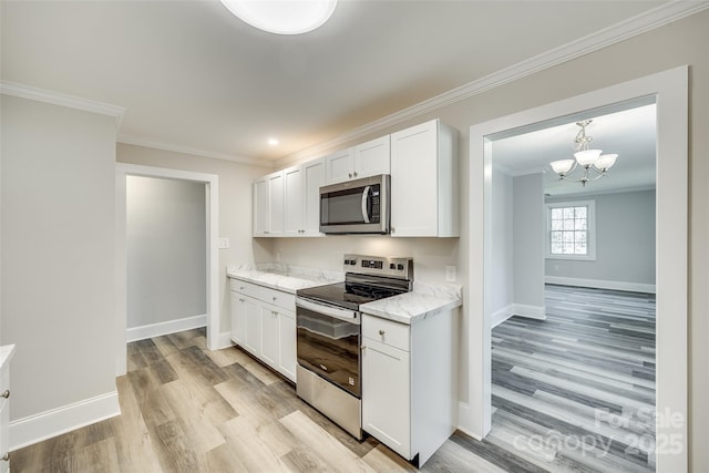 kitchen with white cabinetry, appliances with stainless steel finishes, ornamental molding, and light wood-type flooring