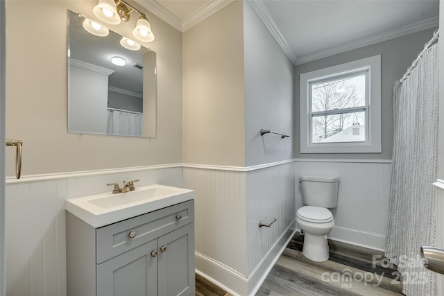 bathroom with crown molding, vanity, hardwood / wood-style flooring, and toilet