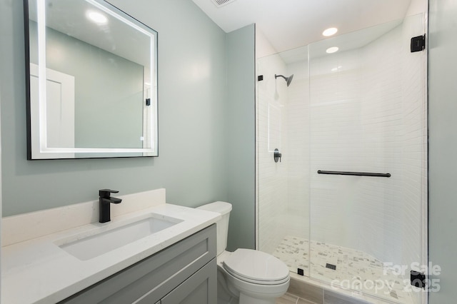 bathroom with an enclosed shower, vanity, and toilet