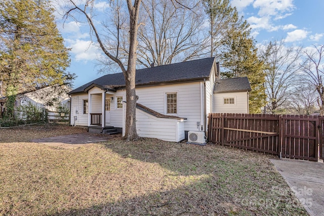 back of house with a lawn and ac unit