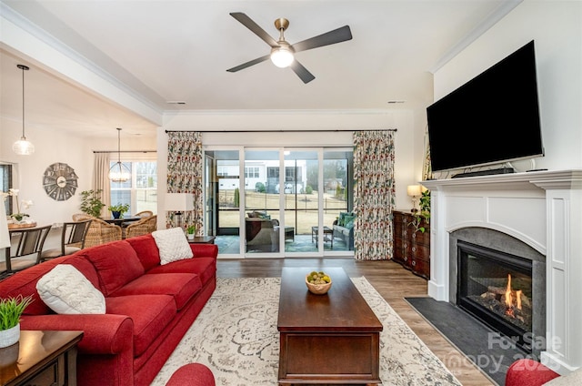 living room with ornamental molding, dark hardwood / wood-style floors, and ceiling fan