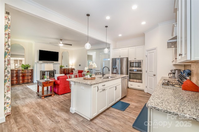 kitchen featuring sink, a center island with sink, and white cabinets