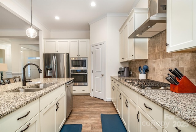 kitchen featuring sink, appliances with stainless steel finishes, hanging light fixtures, light stone counters, and wall chimney exhaust hood