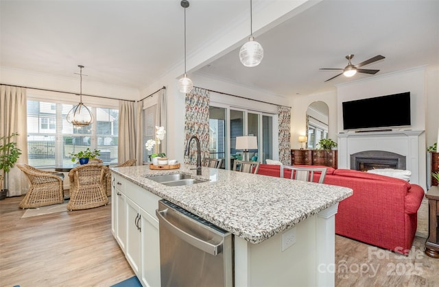 kitchen with sink, hanging light fixtures, an island with sink, white cabinets, and stainless steel dishwasher