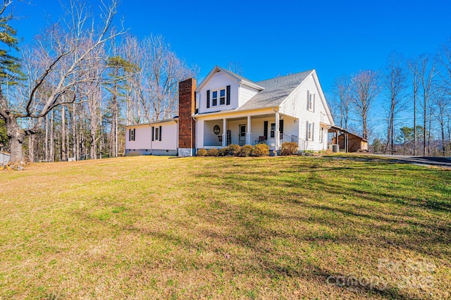 view of side of property with crawl space, a chimney, a porch, and a lawn