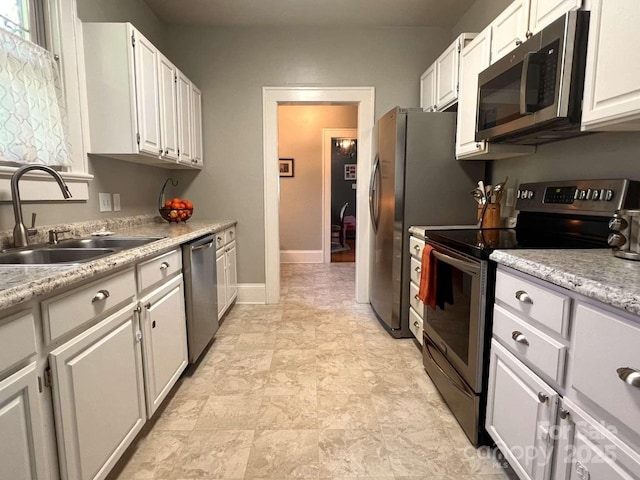 kitchen with white cabinetry, stainless steel appliances, and sink