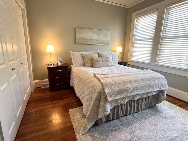 bedroom featuring ornamental molding, dark hardwood / wood-style flooring, and a closet