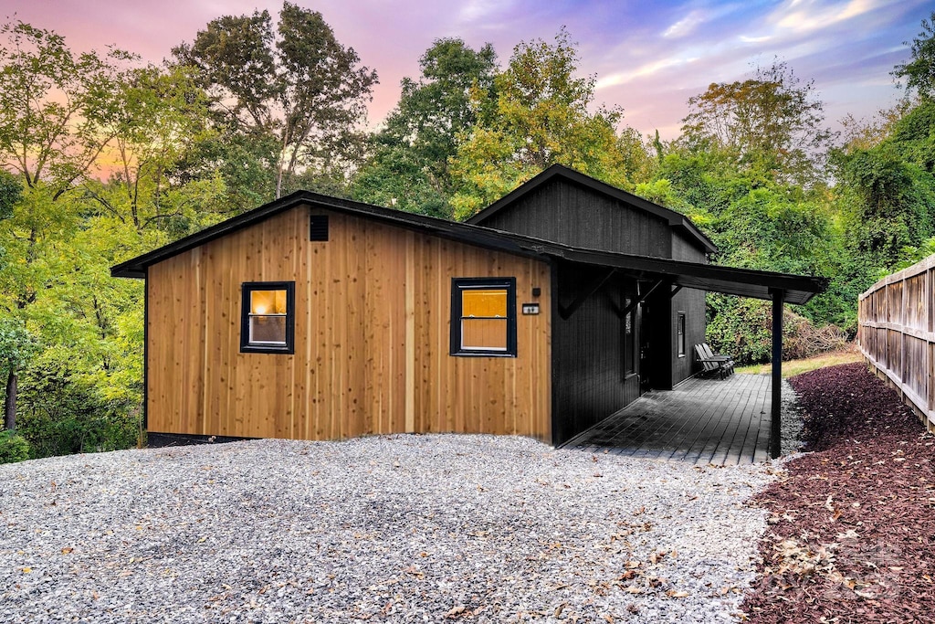 outdoor structure at dusk featuring a carport