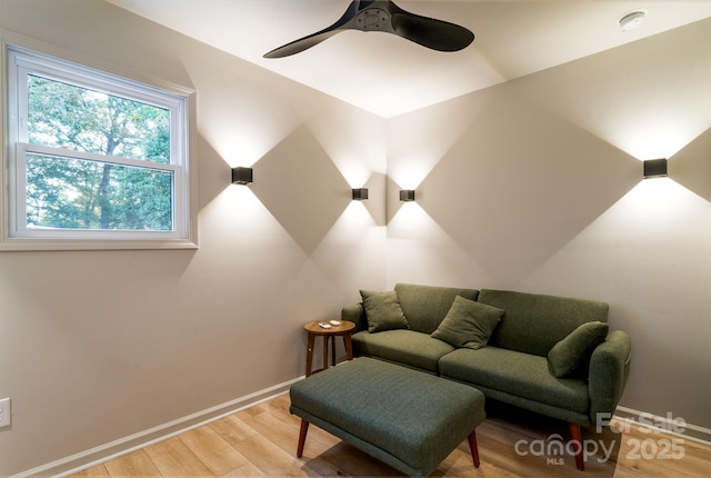 home theater room with light hardwood / wood-style flooring and ceiling fan