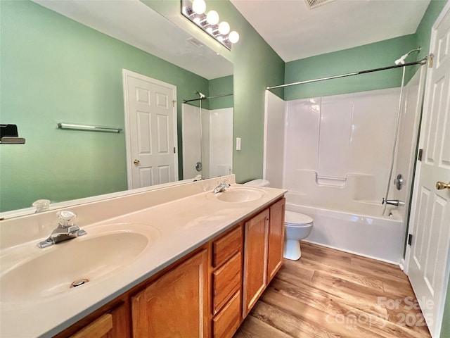 full bathroom with wood-type flooring, toilet, shower / bath combination, and vanity