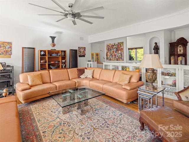 living room featuring hardwood / wood-style floors, crown molding, and ceiling fan