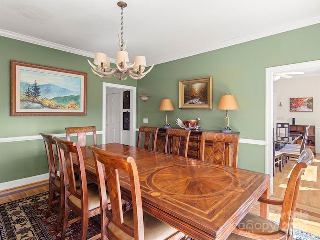 dining space with hardwood / wood-style floors, crown molding, and a notable chandelier