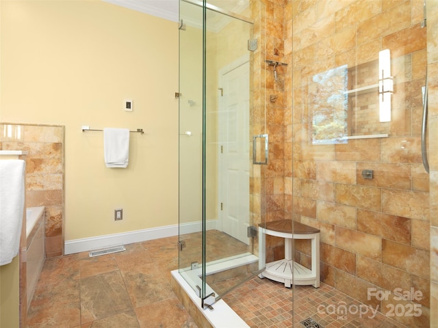 bathroom with walk in shower and ornamental molding