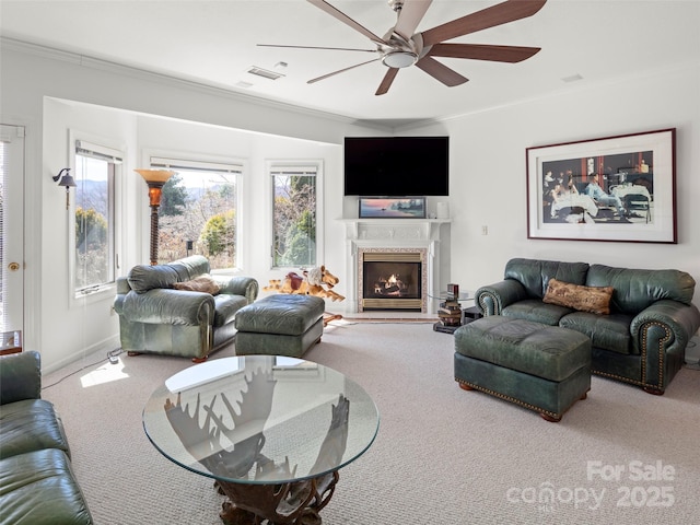 carpeted living room with ornamental molding and ceiling fan