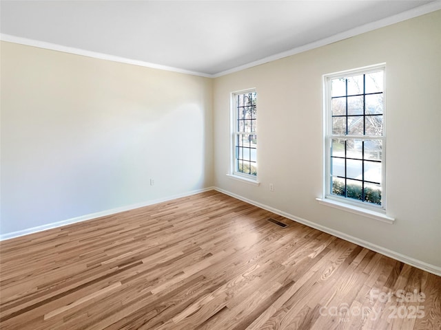 spare room with crown molding and light hardwood / wood-style flooring