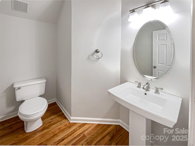 bathroom featuring hardwood / wood-style floors and toilet