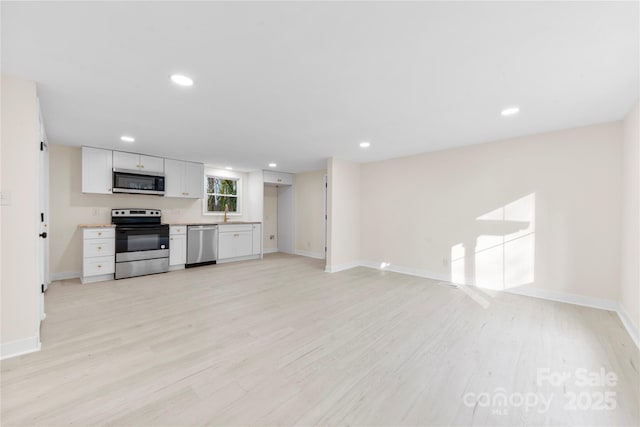 kitchen featuring appliances with stainless steel finishes, sink, light hardwood / wood-style flooring, and white cabinets