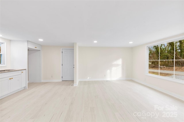 empty room with sink and light wood-type flooring