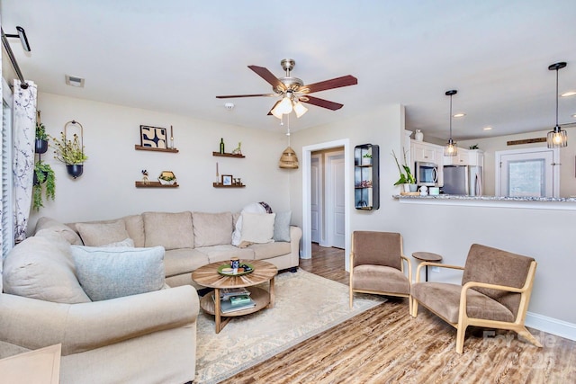 living room with hardwood / wood-style floors and ceiling fan