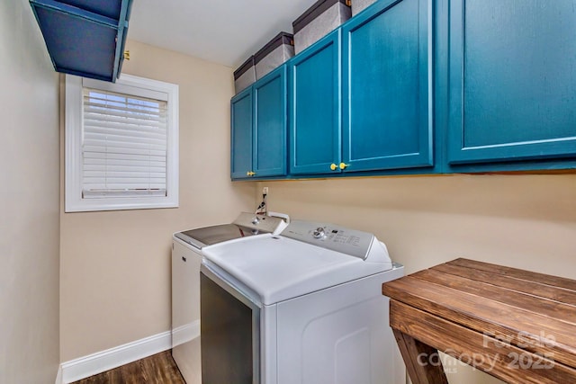 laundry room with cabinets, dark hardwood / wood-style floors, and washing machine and clothes dryer