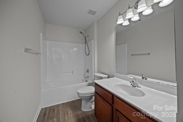 full bathroom featuring shower / washtub combination, hardwood / wood-style floors, vanity, and toilet