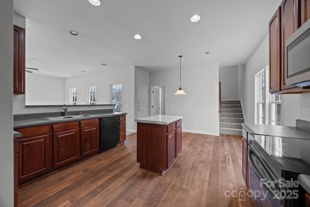 kitchen featuring sink, hanging light fixtures, dark hardwood / wood-style floors, a center island, and black dishwasher