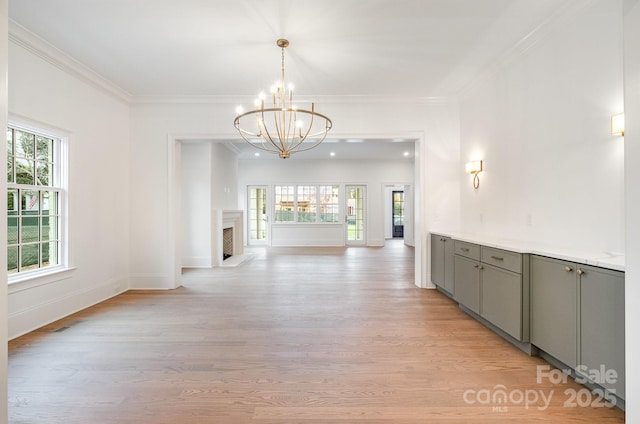 corridor featuring crown molding, light hardwood / wood-style flooring, and a healthy amount of sunlight