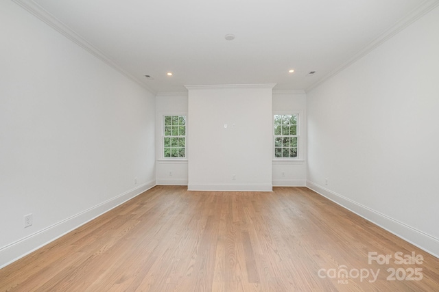 spare room with a healthy amount of sunlight, ornamental molding, and light hardwood / wood-style flooring