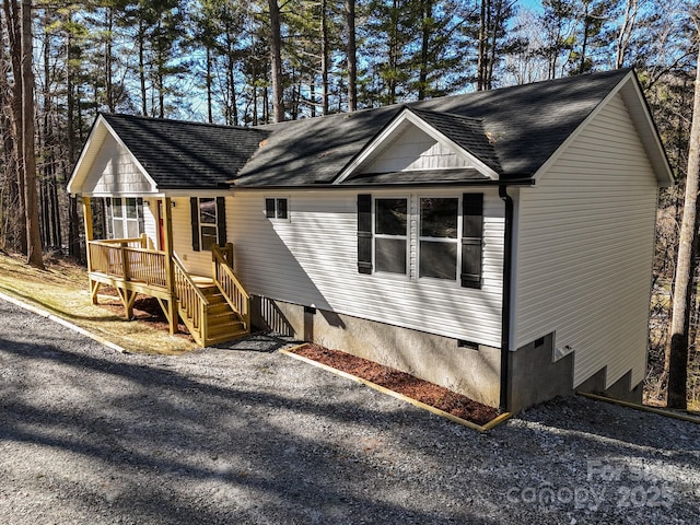 view of front of home with a shingled roof and a deck