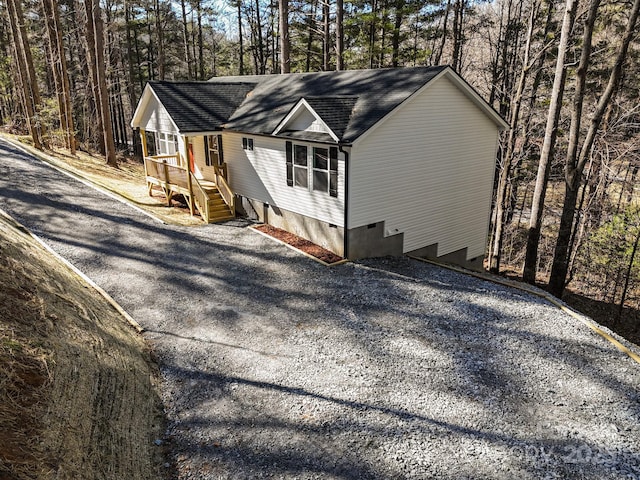 view of property exterior with roof with shingles and crawl space