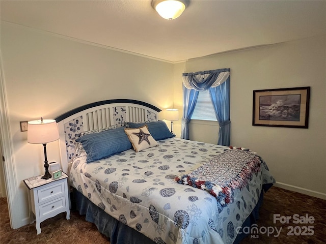 bedroom featuring dark carpet and baseboards