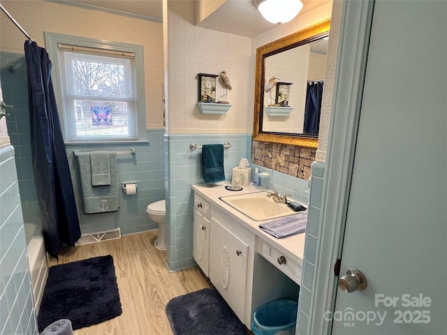 full bath featuring a shower with shower curtain, vanity, toilet, and wood finished floors