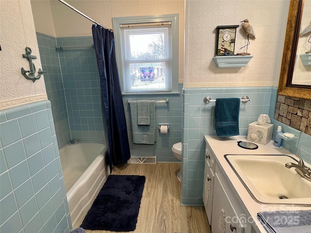 full bathroom with shower / bath combo, wainscoting, toilet, wood finished floors, and vanity