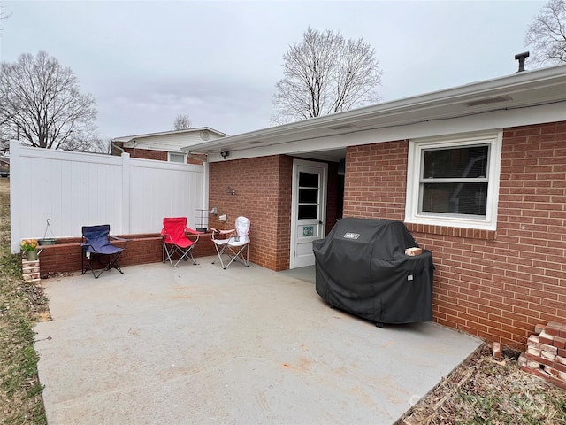 view of patio with area for grilling and fence